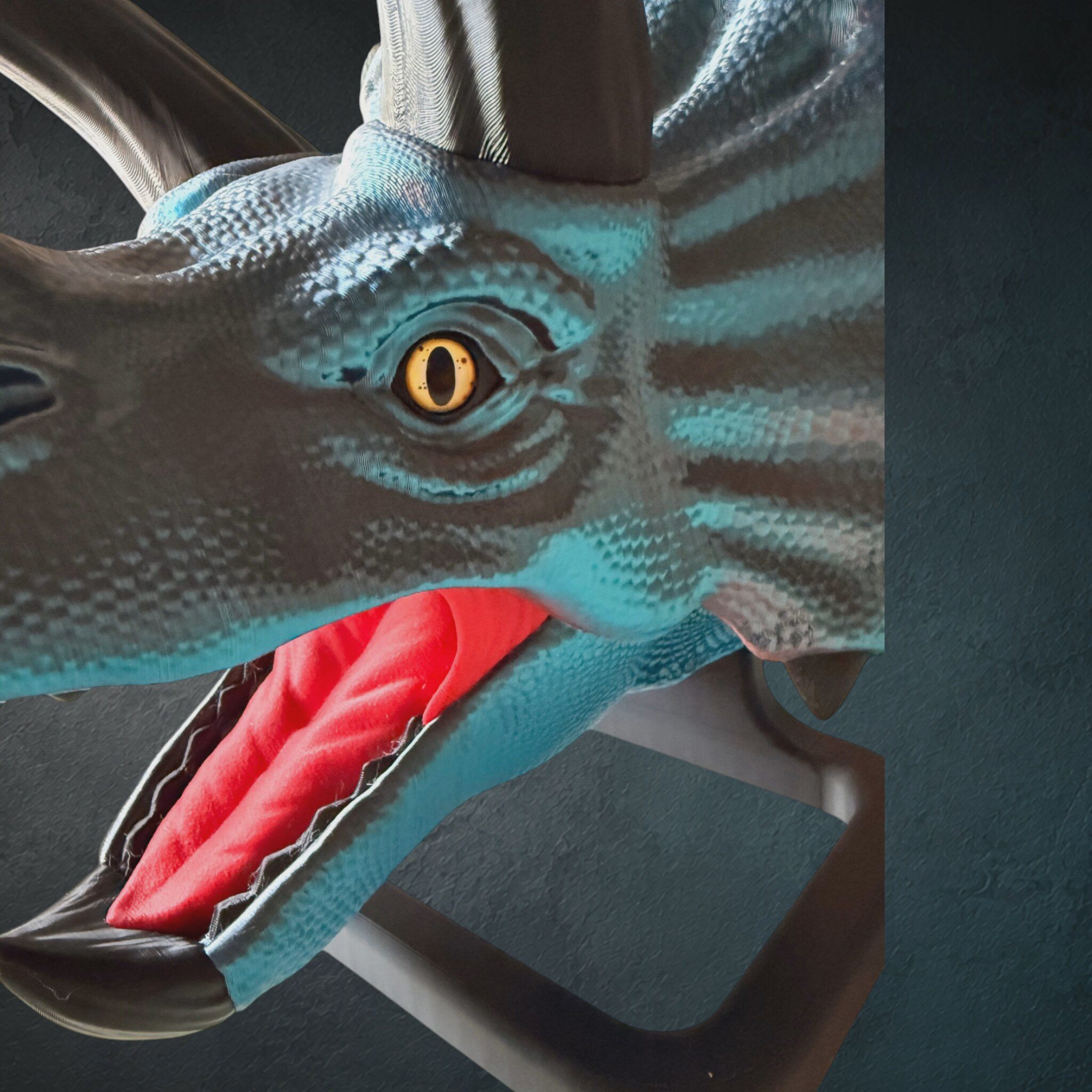 Nahaufnahme des 3D-gedruckten Triceratops-Schädels mit Auge und rotem Maul im schillernden Steampunk-Filament
