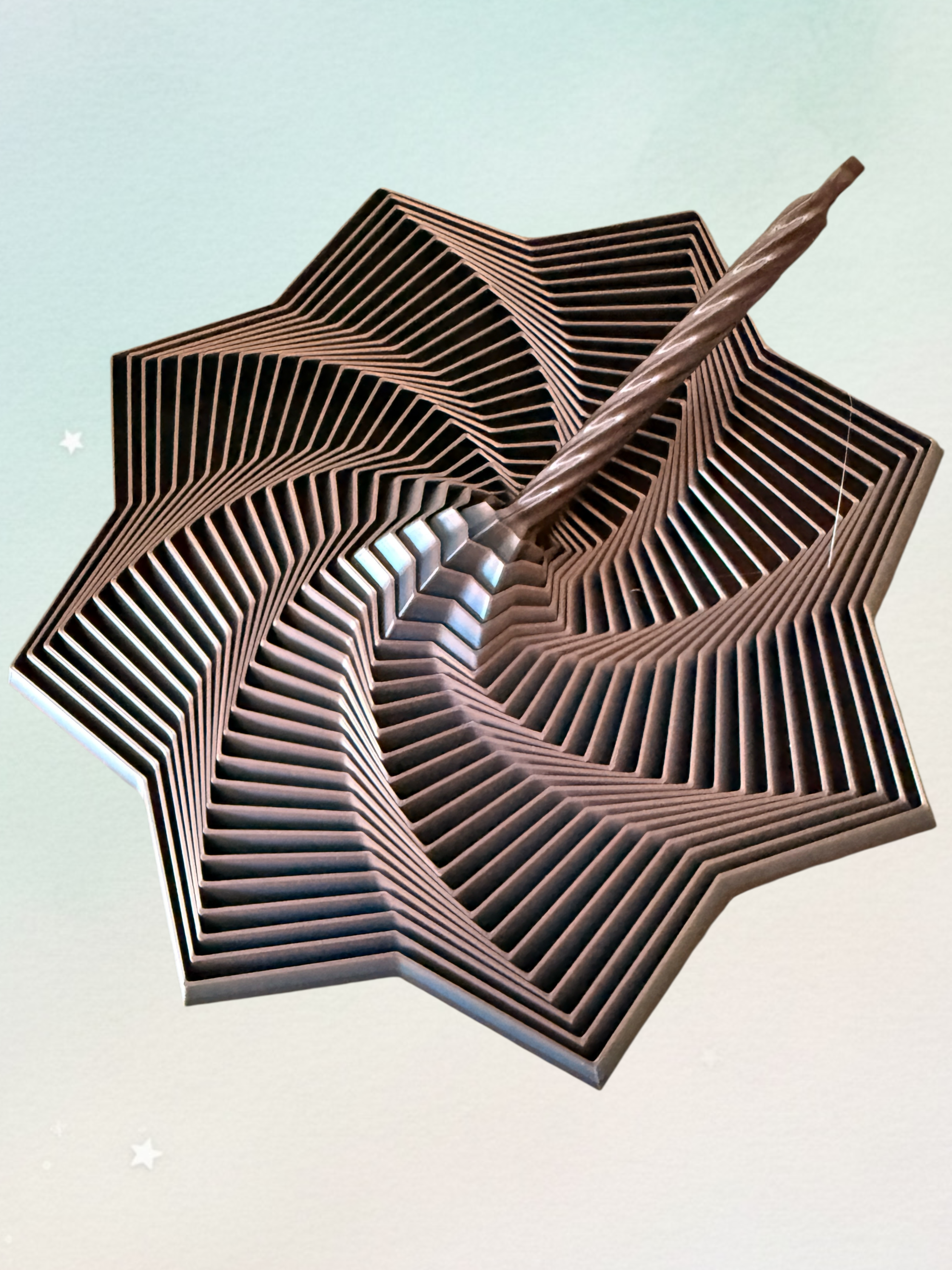 Spiralwirbel-Stern mit Griff vor mintfarbenem Hintergrund mit Sternen-Deko